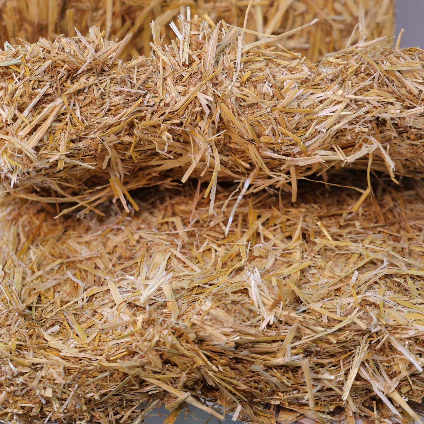 Close-up of clean, bright wheat straw bales for bedding and soil improvement.