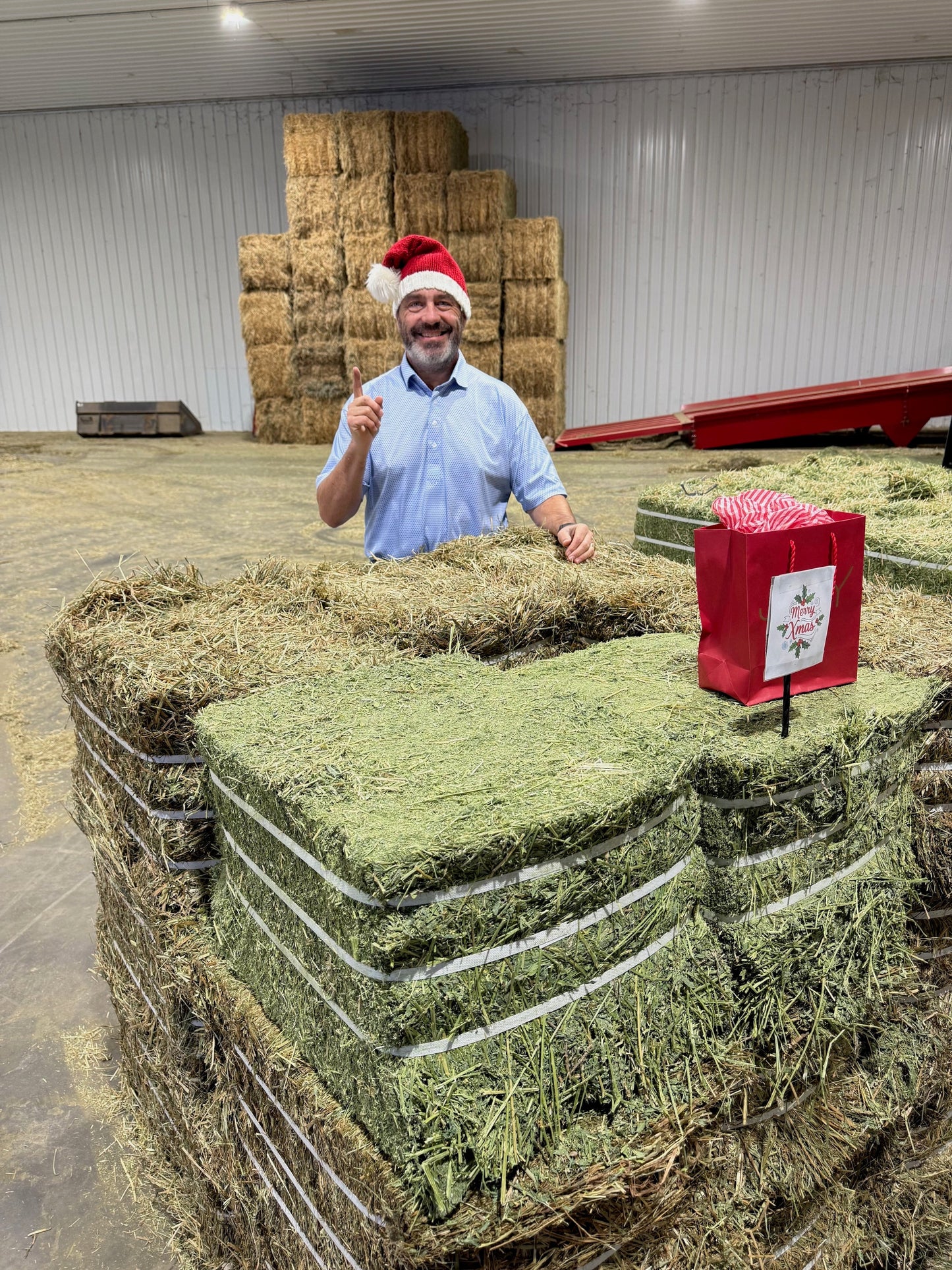 Man wearing Santa hat with stack of hay bales in warehouse Xmas Bundle Promo